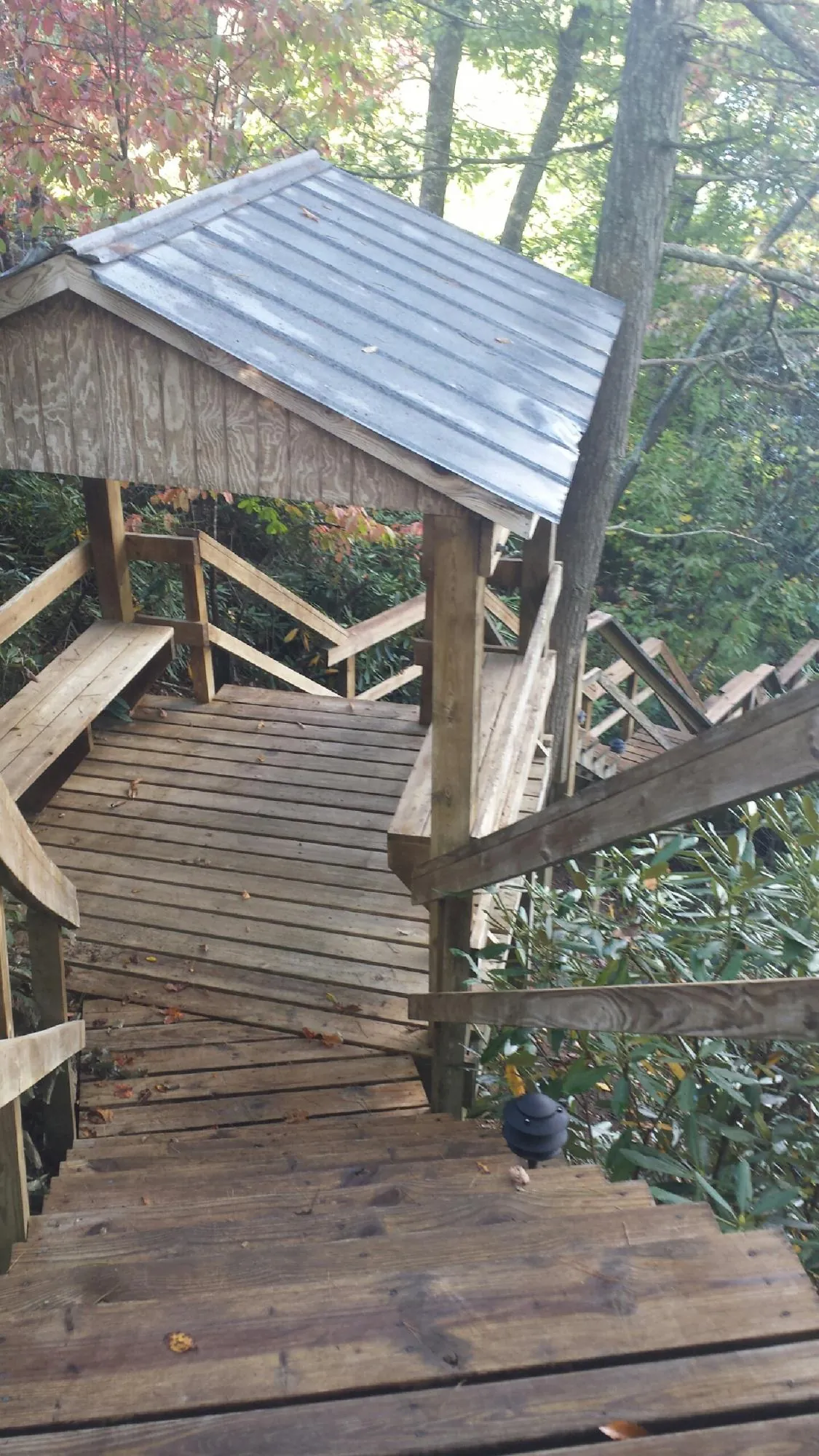 Metal roofed shelter over wooden steps on a wooded walkway — Skylight Repair & Installation work by our crew in Falmouth
